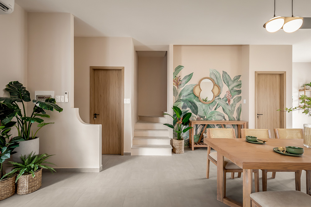 Lối vào nhà gọn gàng, sáng sủa với cây xanh và nội thất gỗ tạo cảm giác dễ chịu