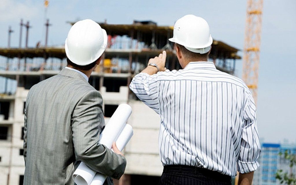 Giám Sát Công Trình Hiệu Quả: Hướng Dẫn Từ A-Z Cho Người Xây Nhà Kỹ sư đội mũ trắng đang giám sát công trình xây dựng thực tế