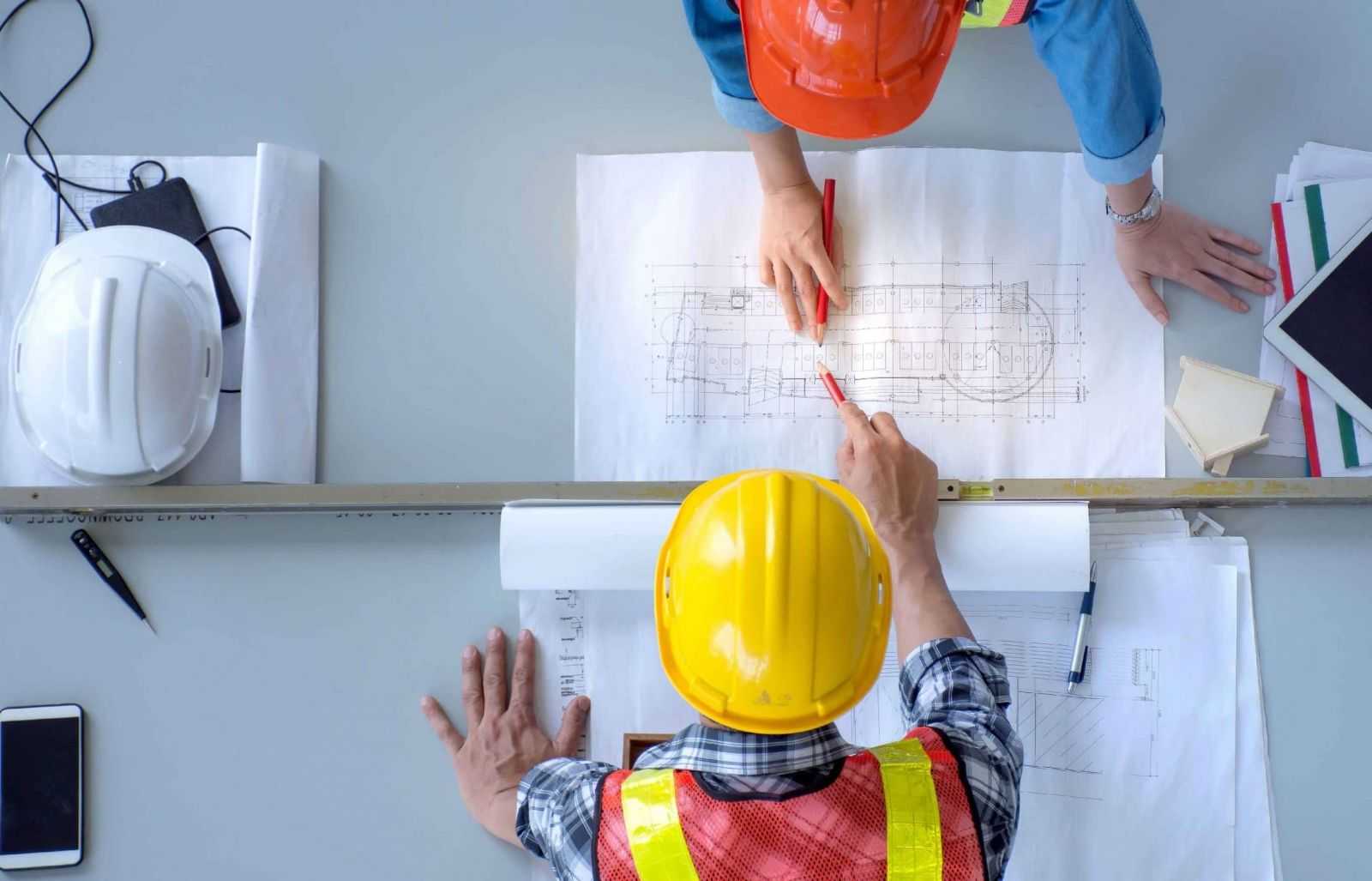 Giám Sát Công Trình Xây Dựng: 7 Bí Quyết Giúp Tránh Sai Lầm Tốn Kém Kỹ sư giám sát công trình trao đổi và kiểm tra bản vẽ kỹ thuật