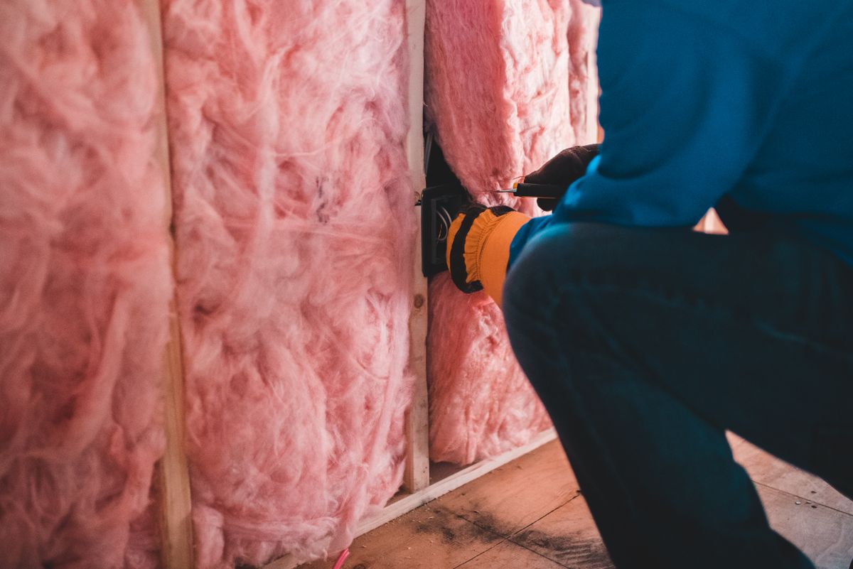 Thợ lắp bông khoáng cách nhiệt giữa các khung