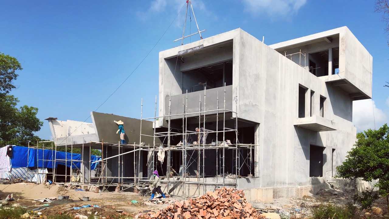 Xây Thô Nhà Ở – Đâu Là Giai Đoạn Không Được Bỏ Qua? Công trình biệt thự hiện đại đang thi công phần thô với giàn giáo và công nhân