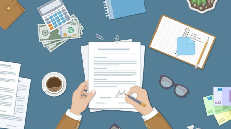 Bàn làm việc với giấy tờ, sổ ghi chú và hợp đồng đang ký – minh họa bước chuẩn bị hồ sơ xin phép xây dựng nhà ở.